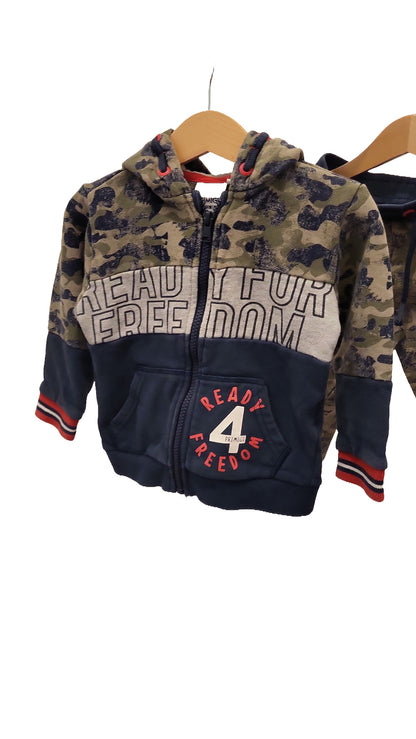 Close-up of the front of the hooded jacket, showing the zip, a front pocket, a red and white '4 Ready Freedom' logo and red-striped cuffs.