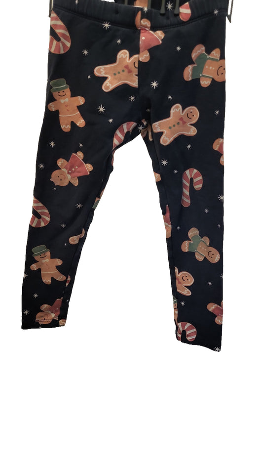 Front of the dark navy leggings, printed all over with gingerbread men and candy canes, hung on a white background.