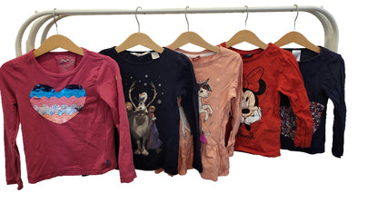 Front view of the five long-sleeved girls' tops on hangers: pink sequin heart top, navy Frozen top, peach unicorn top, red Minnie Mouse top and navy heart top.