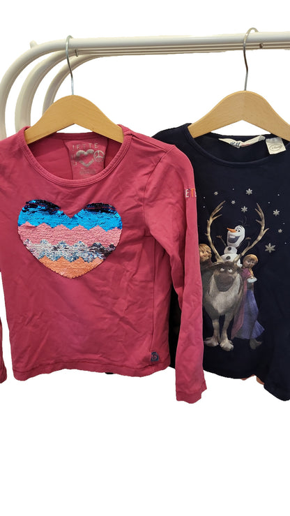 Close-up of the pink top with a reversible sequin heart on the front, and the navy top with Olaf, Sven, Anna and Elsa from Frozen.