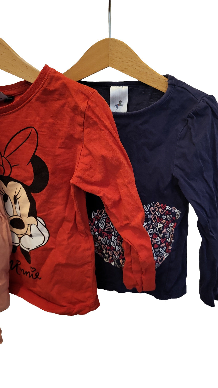 Close-up of the red Minnie Mouse top and the navy top with a heart pattern on the front, showing the sleeves.